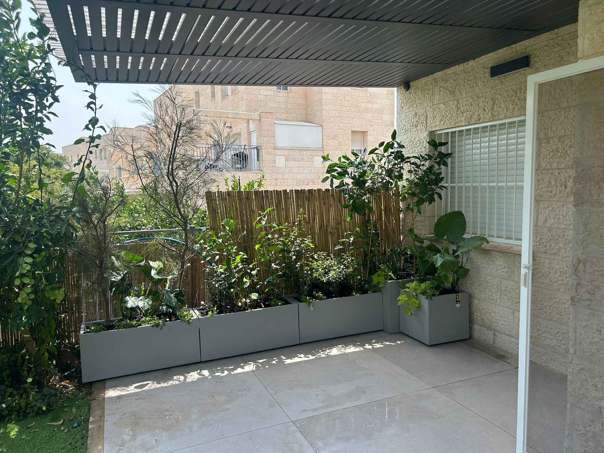 חצר בסגנון טרופי-מודרני | אדניות וכדים דמוי-בטון | פתח תקווה